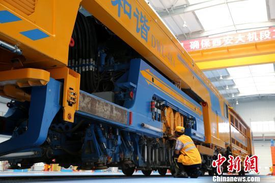 圖為工人正在清理大型養(yǎng)路機(jī)械?！堖h(yuǎn) 攝